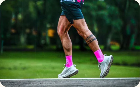 Corredor com meias rosa em treino de corrida no parque